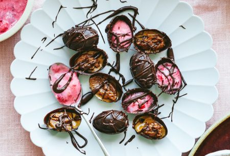 View Chocolate almond Easter eggs Six small chocolate almond Easter eggs on a white plate, cracked in half to show fillings and chocolate drizzle