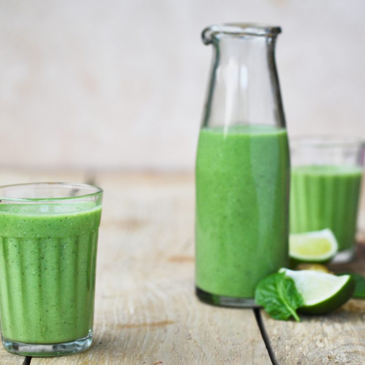 A photo of the green cooler drink with the bottle in the background