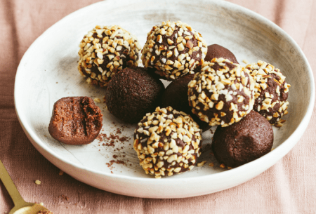 View 10 minute chocolate truffles Bowl of eight chocolate truffles, half coated in finely chopped hazelnuts