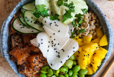 View Poke bowl Super Six style Photo of a poke bowl in a ceramic bowl with super six ingredients including edamame beans, mango and salmon