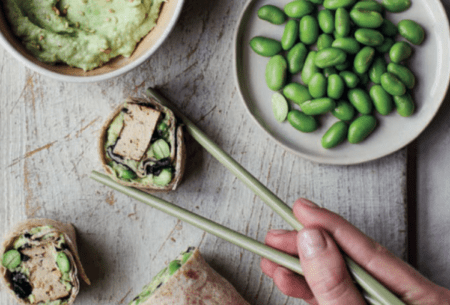 View Fibre-filled breakfast wraps One fibre-filled breakfast wrap cut into sushi pieces. Displayed with chopsticks, extra edamame beans and homemade spread