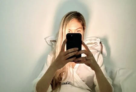 View Smartphone blues? How your phone affects your sleep Megan Rossi in bed with phone infront of her face scrolling