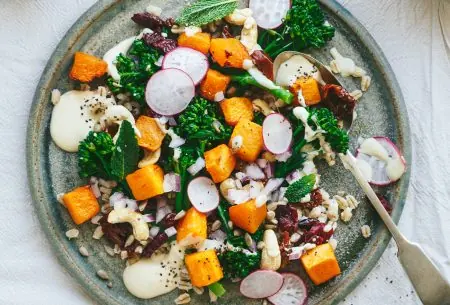 View Barley, broccoli & butternut squash salad One plate of fresh summer barley and butternut squash salad sat on a bench top