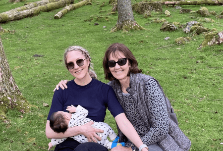 View Breastfeeding benefits Dr Megan Rossi sitting outside on the grass with mother and new born child