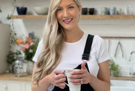 View Could coffee have similar benefits to plant foods? Dr Megan Rossi standing in a kitchen holding a ceramic mug between her hands