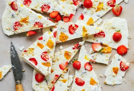 View Frozen live yoghurt bark One large frozen live yoghurt bark, broken roughly into 12 pieces on a grey bench top