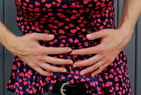 View Is constipation really what we think it is? A female stomach with two hands placed on the stomach