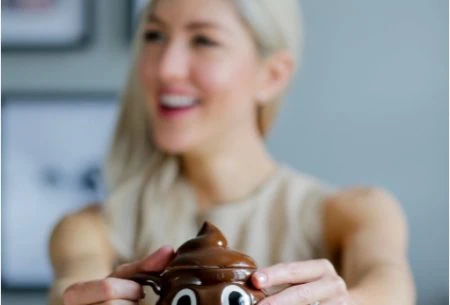 View Should your poop sink or float? Megan holding a poo shaped mug
