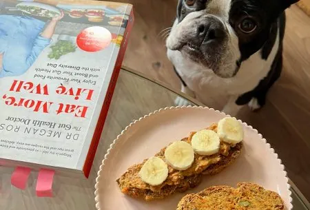 View Not adding vege to your bread? Here’s why you should… Two pieces of bread topped with banana slices, showing dog and The Gut Health Dr book 'Eat Well, Live More' in background