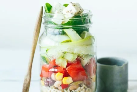 View Zingy salad jars One large zingy salad jar displayed in a mason jar and layered with salad ingredients. Small pot of dressing on the side