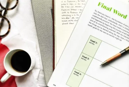 View Setting goals A mug of coffee, journal and final word page to write goals with notes