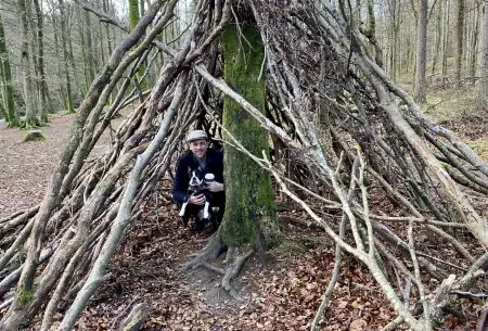 View The power of nature A cave in the woods made of sticks with man and dog inside