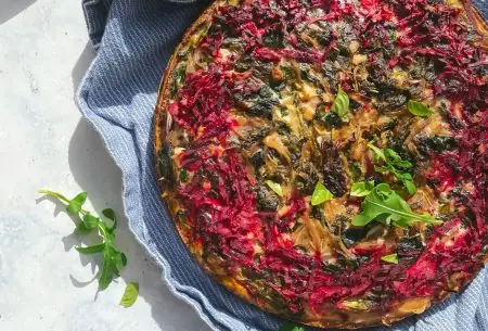 View Moreish beetroot tart Fresh cooked full moreish spiced beetroot tart on bench with blue serving towel