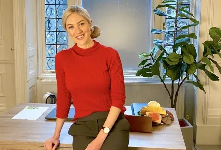 View Gut health & PCOS: is there a link? Megan Rossi sat on the edge of her desk in a red jumper