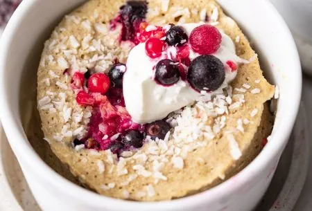 View Banana mug muffins A photo of one of the mug cakes, in a white ramekin, topped with fresh berries and yoghurt