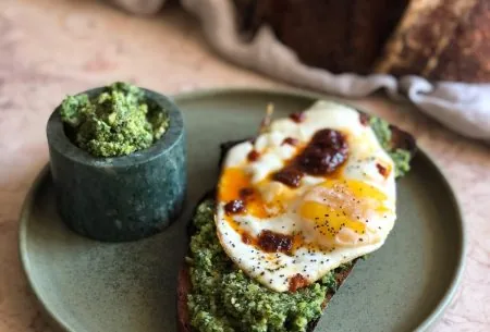 View Walnut & Brussels sprout pesto & egg on sourdough Pot of walnut and brussels sprout pesto with fried egg on sourdough toast