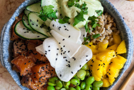 View Poke bowl Super Six style Photo of a poke bowl in a ceramic bowl with super six ingredients including edamame beans, mango and salmon