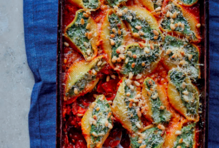 View Spinach & ricotta stuffed pasta shells Oven tray full of freshly baked spinach and ricotta pasta shells with serving spoon