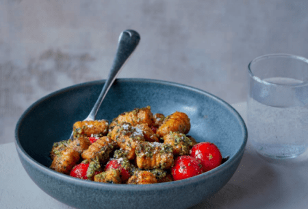 View Super pesto A blue bowl of sweet potato gnocchi covered in super pesto