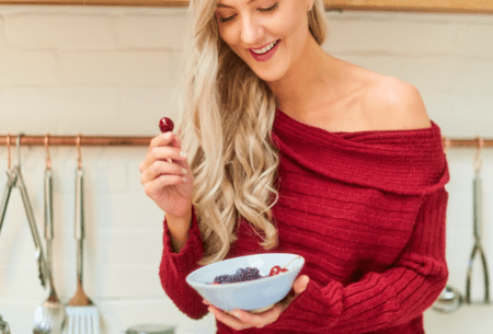 View International Women’s Day: nutrition & the life cycle Megan Rossi sitting on the work surface eating a bowl of cherries and berries