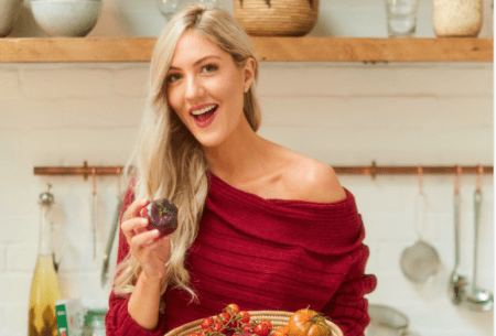 View Could rearranging our supermarkets change the way we eat? Dr Megan Rossi standing in a kitchen holding a large bowl of mixed vegetables