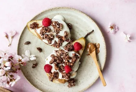 View ‘PRObiotics’ in cereals: why it’s just a gimmick A plate with a pear halved with yogurt, nut butter, granola and nut butter on top with a spoon of nut butter on the side of the plate