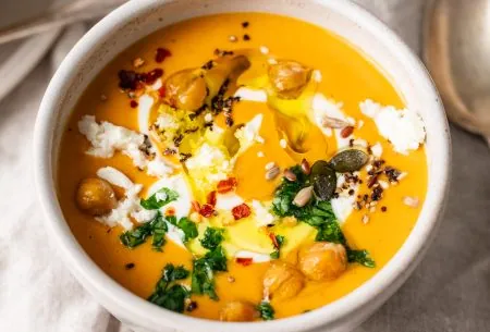 View Protein-loaded pumpkin soup A photo of a bowl of pumpkin soup, topped with chickpeas, parsley & feta