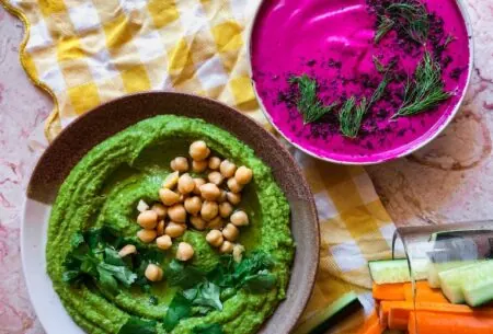 View Summer beetroot & green hummus dips Photo of gut health friendly summer dips green hummus and beetroot dip on a table with vegetable sticks