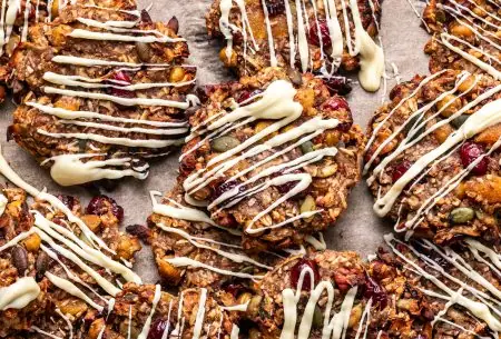 View Hidden plants trail mix cookies A photo of the trail mix cookies laid out on a table with white chocolate drizzled over them