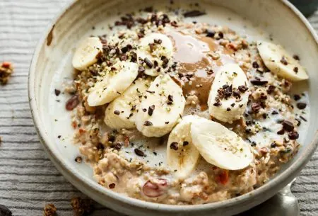 View Health & wellbeing during Ramadan Bowl of porridge topped with banana, grated chocolate and hemp seeds