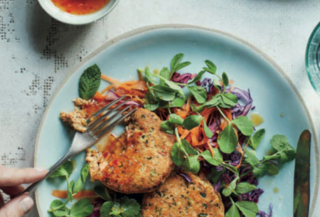 View Thai-inspired fishcakes & crunchy salad Two cooked fishcakes on top of a fresh, crunchy salad with a pot of homemade dressing